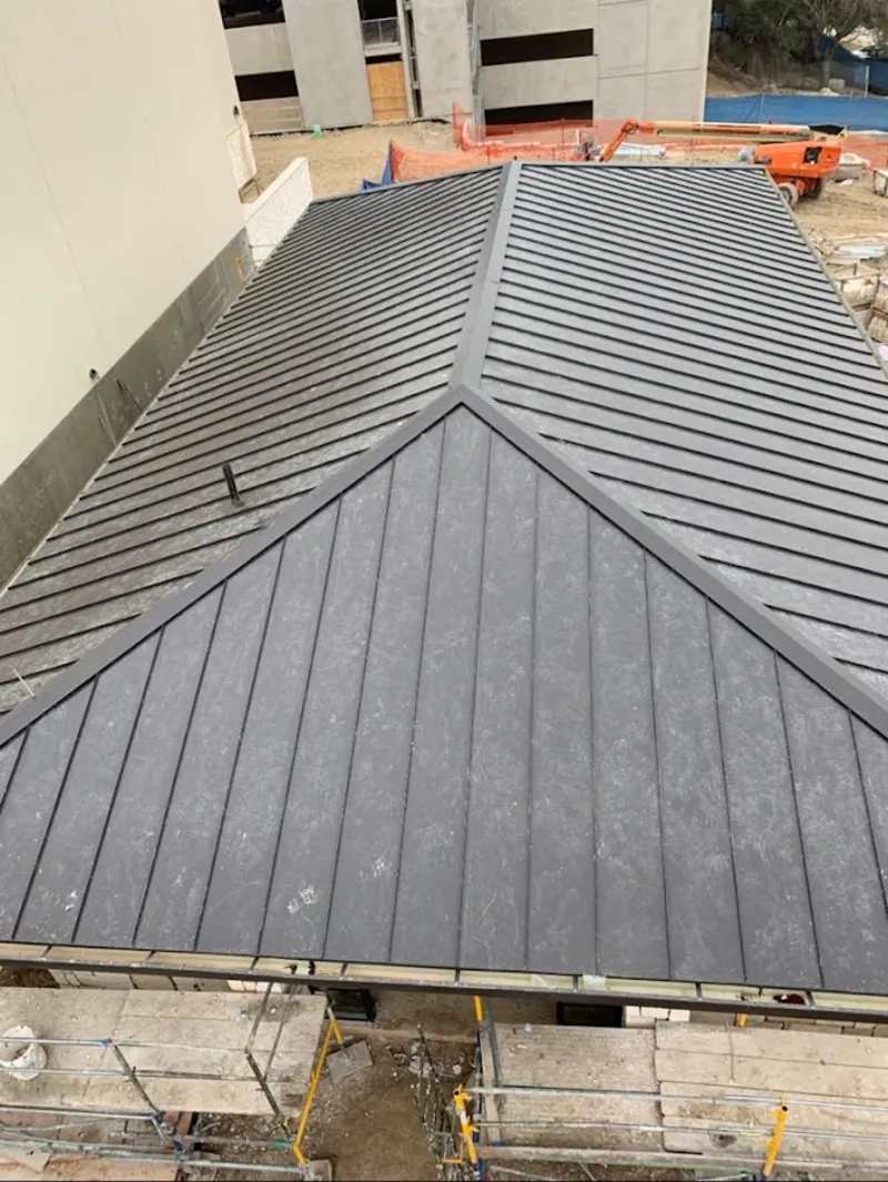 Commercial metal roof construction with crane equipment in Arvin